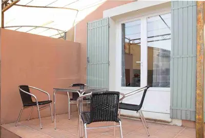 a patio with a table and chairs and a window at Gîte les coquelicots 2 Quartier résidentiel ( 2 * ) in LʼIsle-sur-la-Sorgue