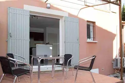 a patio with a table and chairs on a balcony at Gîte les coquelicots 2 Quartier résidentiel ( 2 * ) in LʼIsle-sur-la-Sorgue