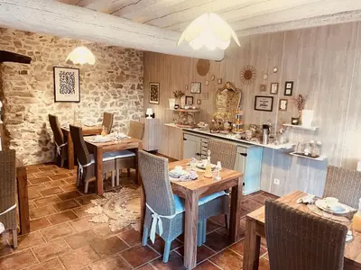 a restaurant with wooden tables and chairs and a counter at B&B Temps Suspendu Provence in Pernes-les-Fontaines