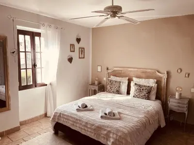 a bedroom with a bed with shoes on it at B&B Temps Suspendu Provence in Pernes-les-Fontaines