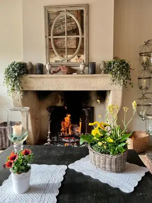 a living room with a fireplace with flowers and candles at Villa Hautvallon - Peaceful Escape in Provence in Gordes
