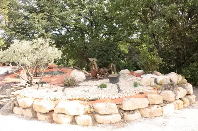 a garden with a pile of rocks and trees at Lou Cigalon in Cabrières-dʼAvignon