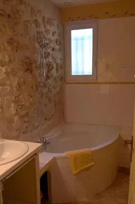 a bathroom with a tub and a sink and a window at Gîte La Charlette in Cheval-Blanc