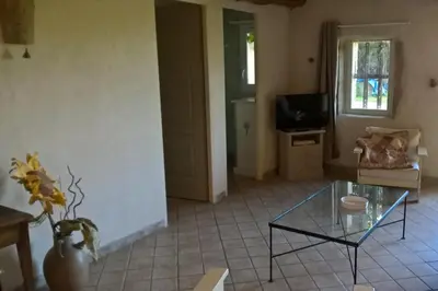 a living room with a glass table and a couch at Gîte La Charlette in Cheval-Blanc