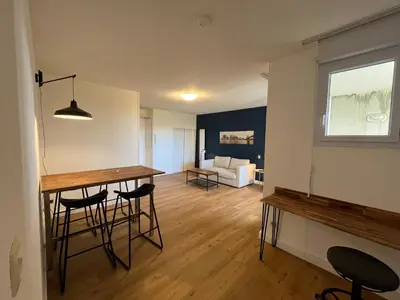a kitchen and living room with a table and chairs at Les appartements du Clos de la Chartreuse By Ateya in Aix-en-Provence