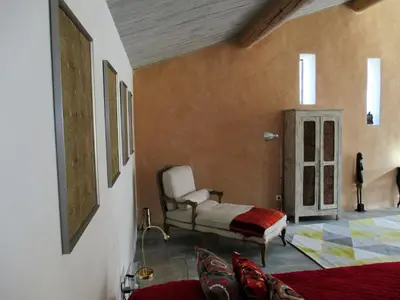 a bedroom with a bed and a chair in a room at Le Mas du Fort in Gargas