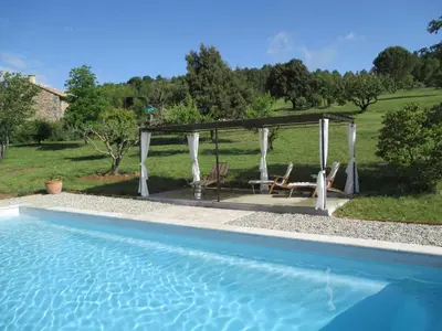a pool with a gazebo and a table and chairs at Le Mas du Fort in Gargas