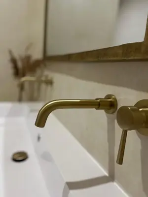 a bathroom sink with a gold faucet at La Suite du clocher in Noves