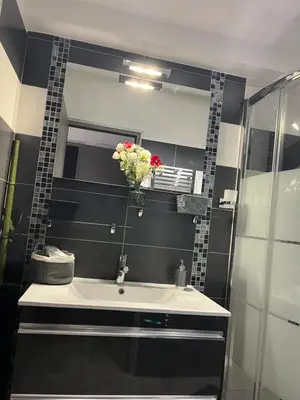 a bathroom with a sink and a vase of flowers at L'AMANDERAIE PISCINE PRIVEE à côté de LOURMARIN LUBERON in Cadenet