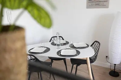 a table with chairs and a white table with glasses on it at L'Isle en Blanc - 4 couchages - Hypercentre - Clim - Wifi in LʼIsle-sur-la-Sorgue