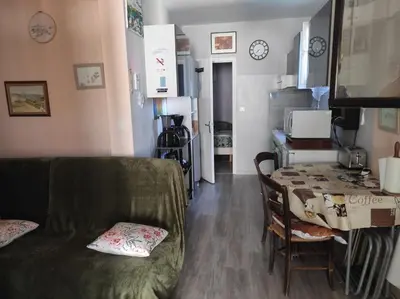 a living room with a table and a couch at Au petit Florian en Provence in Apt