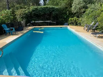 a large blue swimming pool with chairs around it at Mas Grimaud - Gîte- Studio et chambres d'hôtes familiales in Eygalières