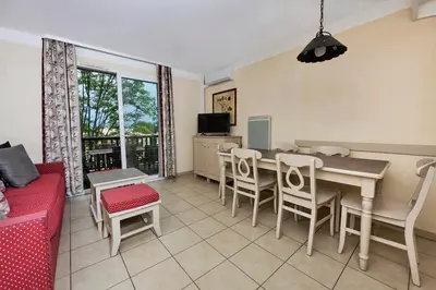 a living room with a dining room table and chairs at Bastidon Golf de Pont Royal in Mallemort