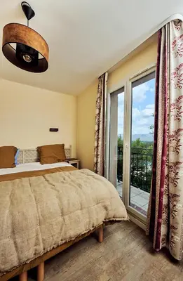 a bedroom with a bed and a large window at Bastidon Golf de Pont Royal in Mallemort