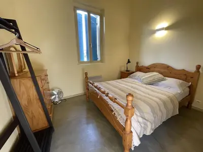 a bedroom with a wooden bed and a window at Auberge de Mazan in Mazan