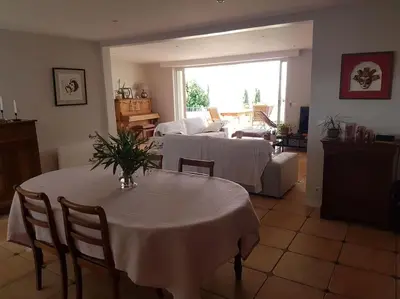 a living room with a table and a couch at Charmante villa 4 chambres, piscine et superbe vue in Éguilles