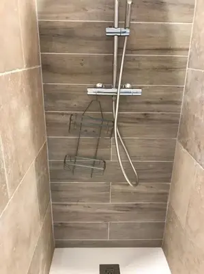a shower with a hose in a bathroom with tiles at Imola - Côté Ventoux in Bédoin