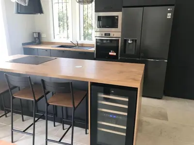 a kitchen with a wooden counter with stools and appliances at Imola - Côté Ventoux in Bédoin