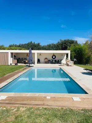 a swimming pool in front of a house at Villa avec Pool House au cœur des vignes - Lubéron in La Tour-dʼAigues