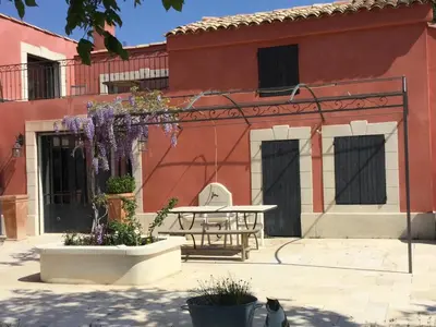 a patio with a table in front of a building at Villa avec Pool House au cœur des vignes - Lubéron in La Tour-dʼAigues