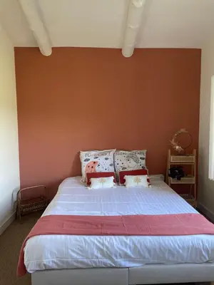 a bedroom with a large bed with pillows on it at Villa avec Pool House au cœur des vignes - Lubéron in La Tour-dʼAigues