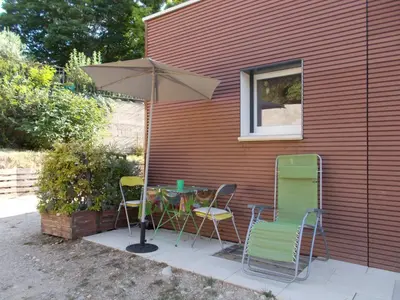 a patio with a table and chairs and an umbrella at studio Erilys in Apt