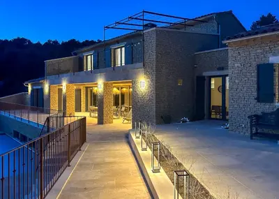 a house with a patio and a swimming pool at night at Mas La Rose Sauvage - magnificent Luberon views in Murs