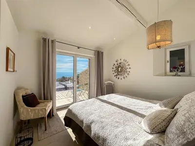 a bedroom with a bed and a large window at Mas La Rose Sauvage - magnificent Luberon views in Murs