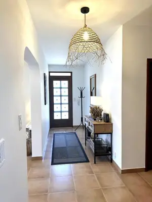 a hallway with a door and a chandelier at Les Lauriers Blancs air-conditioned villa with swimming pool in LʼIsle-sur-la-Sorgue
