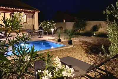 a backyard with a swimming pool at night at Les Lauriers Blancs air-conditioned villa with swimming pool in LʼIsle-sur-la-Sorgue