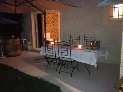 a table with candles and chairs on a patio at night at Mas du Soleil in Caumont-sur-Durance