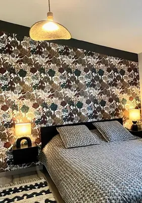 a bedroom with a bed with a floral wall at B&B 2 Chambres d'hôtes Gai Félibre avec Piscine et Jacuzzi in Le Thor