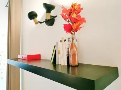a vase with flowers on a shelf with books at Grand studio lumineux au calme, centre historique in Pertuis