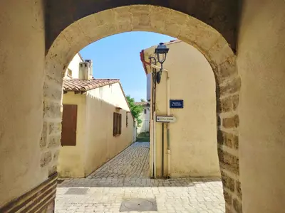 an archway in an alley in a town with buildings at Grand studio lumineux au calme, centre historique in Pertuis