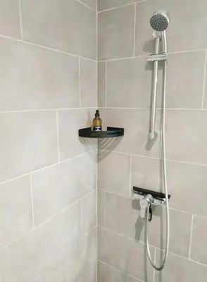 a shower with a shower head in a bathroom at Grand studio lumineux au calme, centre historique in Pertuis