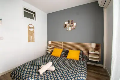 a bedroom with a bed with two yellow pillows at Les quatre loges n°1 in Aix-en-Provence