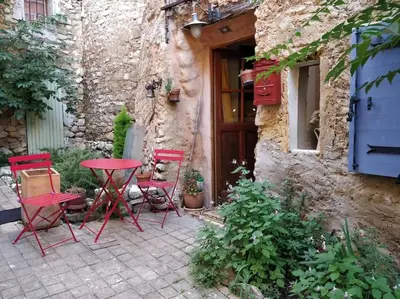 a red table and chairs in front of a building at Maisonnette au pied du Mont Ventoux ste colombe in Bédoin