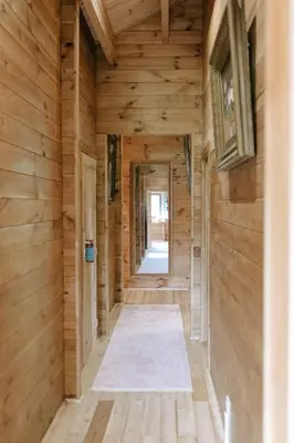 a hallway in a log cabin with wooden walls at Charming ecolodge with private access to the river in Le Thor
