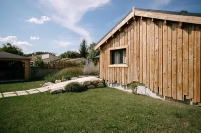 a wooden building with a window in a yard at Charming ecolodge with private access to the river in Le Thor