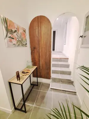 a hallway with a wooden door and a table at Appartement lumineux , Carpentras centre in Carpentras