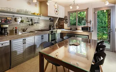 a kitchen with a wooden table and chairs at VillaOustal. Parc Arboré 4500 m2. Piscine chauffée. in Carpentras