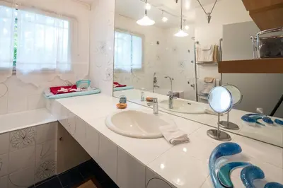a white bathroom with a sink and a mirror at VillaOustal. Parc Arboré 4500 m2. Piscine chauffée. in Carpentras