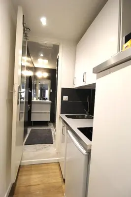 a kitchen with white cabinets and a sink and a stove at Studio centre historique derrière rue d'Italie - Climatisé in Aix-en-Provence