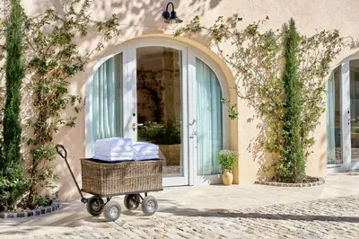 a cart filled with towels in front of a building at Auberge La Coste in Le Puy-Sainte-Réparade