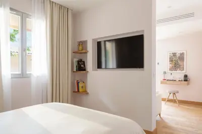 a bedroom with a bed and a tv on a wall at Auberge La Coste in Le Puy-Sainte-Réparade