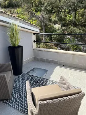 a patio with a table and chairs on a balcony at Villa en Provence, Spa & piscine, pour 9 personnes- Gîtes les Estelles in Cavaillon