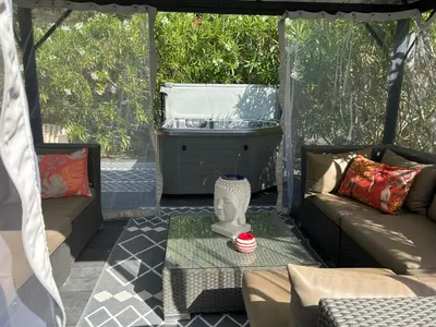 a screened in porch with two couches and a fountain at Villa en Provence, Spa & piscine, pour 9 personnes- Gîtes les Estelles in Cavaillon