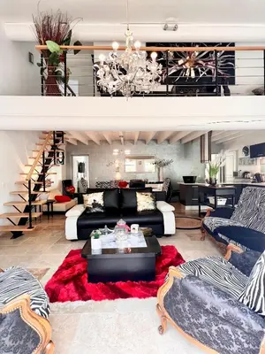 a living room with a black couch and a red rug at Villa en Provence, Spa & piscine, pour 9 personnes- Gîtes les Estelles in Cavaillon