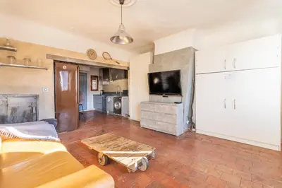 a living room with a couch and a table and a tv at Authentique Appartement Aixois in Aix-en-Provence