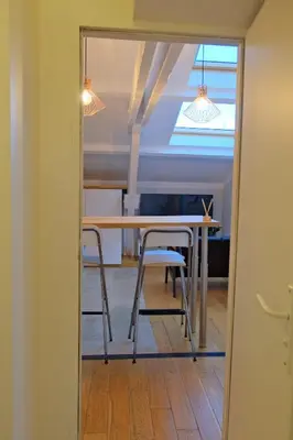 a table and chairs in a room with a ceiling at Isabelli Appartement plein centre avec place de parking in Aix-en-Provence